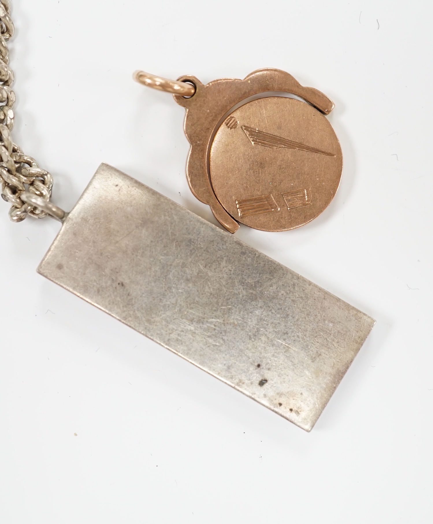 A 9ct gold swivelling masonic pendant, 12.3 grams and a silver ingot pendant, on a 925 chain.